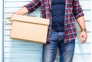 Student with a box standing outside a student self storage facility