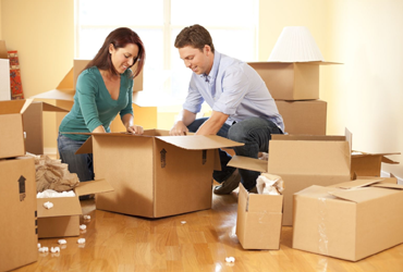 Woman and man packing items in boxes to be put in self storage containers