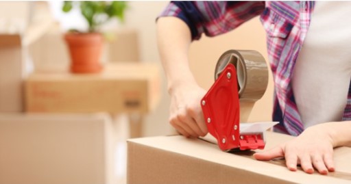 Woman sealing her box to be put in a personal self storage